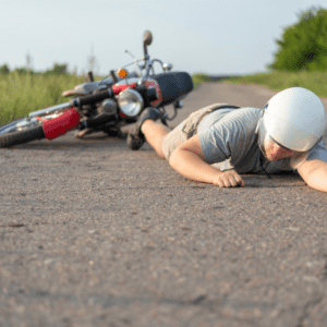 Person lying on the ground after a motorcycle accident